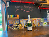 Celebrate your honeymoon in a cozy RV rental! This inviting interior features champagne, decorative tiles, and a custom chalkboard message.
