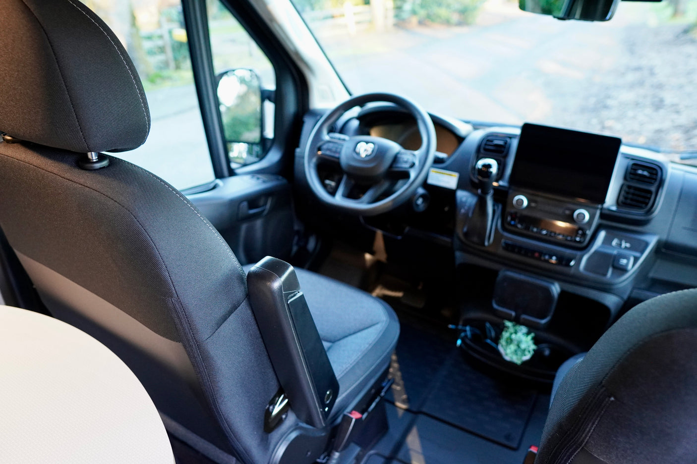 Interior of an **rv rental** showing the cockpit from the passenger seat, featuring the dashboard, steering wheel, and screen.