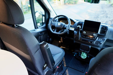 Interior of an **rv rental** showing the cockpit from the passenger seat, featuring the dashboard, steering wheel, and screen.