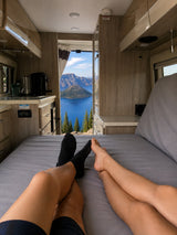 Relaxing in an RV rental with a breathtaking view of Crater Lake from the comfort of our bed.