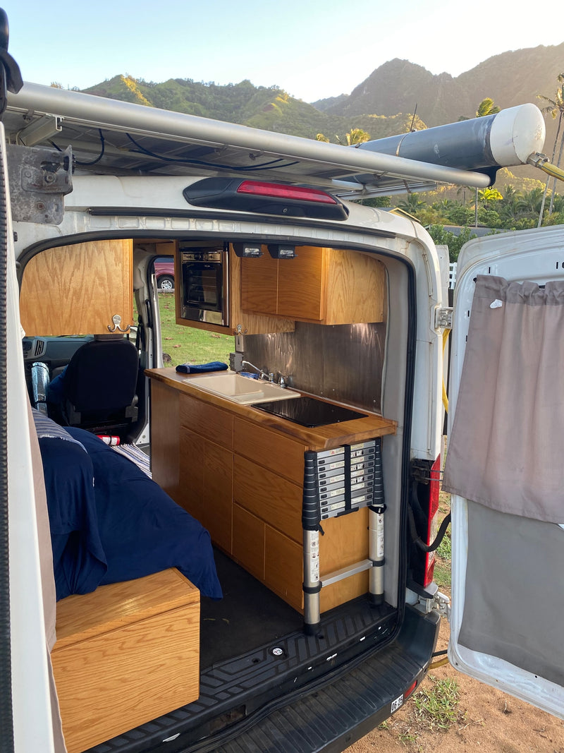 Explore in this RV rental camper van! Full kitchen, bed, roof water tank, and stunning mountain views. — photo 17