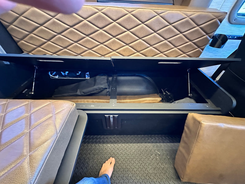  and comfortable bed area.|Spacious RV rental interior with convertible tan benches — photo 12