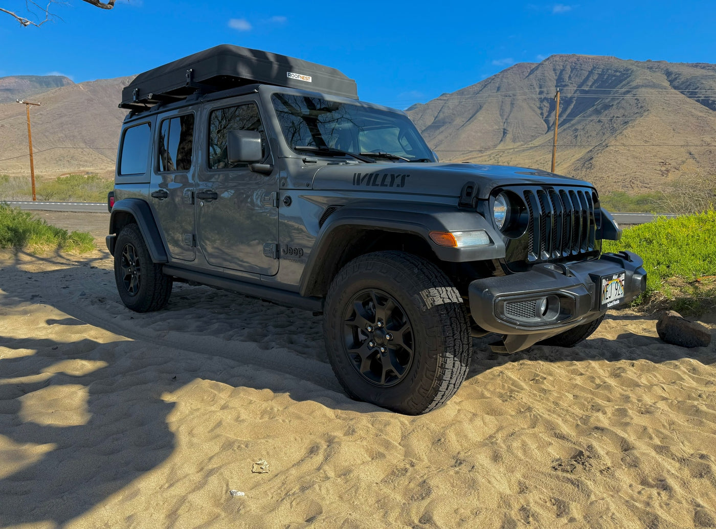 Gray Jeep Wrangler RV rental with rooftop tent on a Maui beach, mountains in background. Ready for island exploration. — photo 10