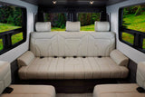Spacious RV rental interior with panoramic nature views and convertible seating for comfortable travel and camping.