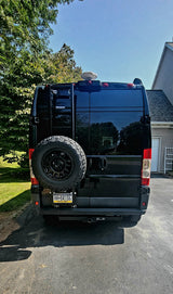 Rear of a black RV camper van, perfect for RV rental. Shows spare tire, ladder, and PA 'MOTOR HOME' license plate.