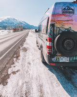 An Aspen Custom Vans camper van, perfect for RV rental adventures, parked on a snowy Colorado mountain road.