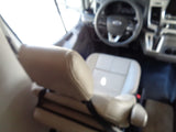 Inside an RV rental: Driver's cabin view with Ford steering wheel, dashboard, and light-colored seats.