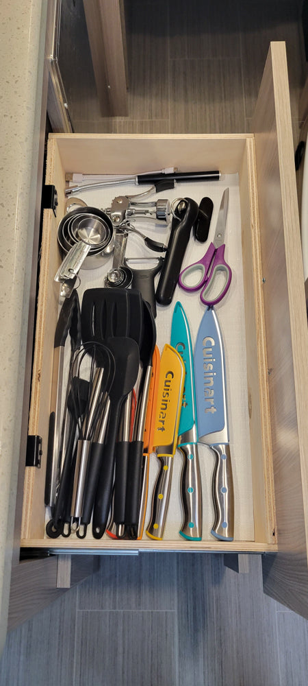 Neatly organized kitchen drawer in an RV rental, packed with essential cooking utensils like spatulas, knives, measuring cups, and more.