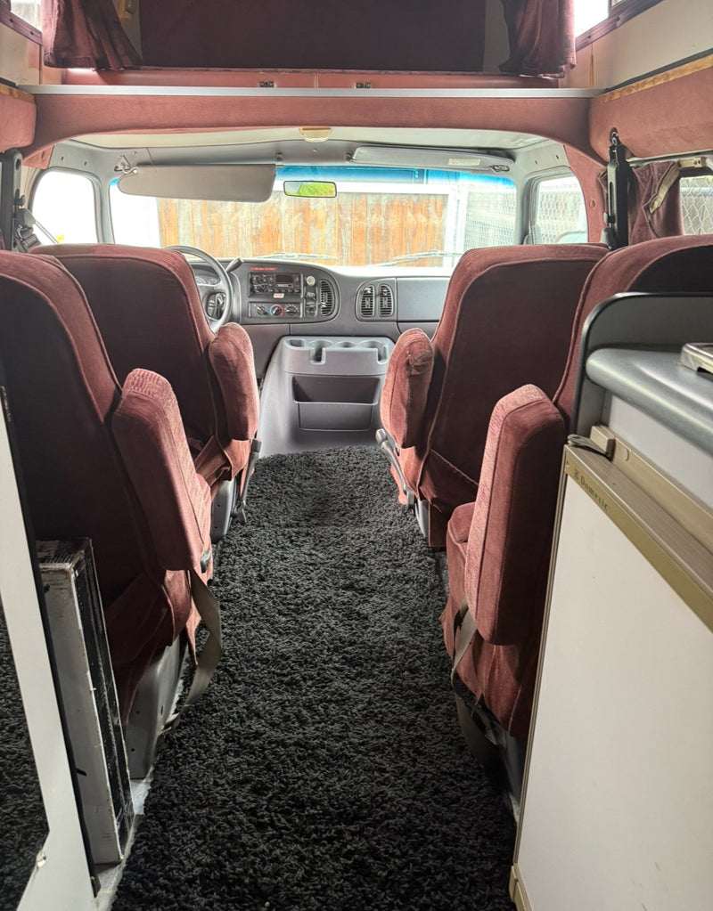  nestled against dark red walls.|RV rental: A detailed list of features including stove — photo 11