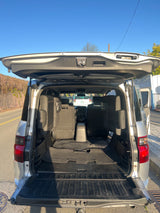 Spacious SUV interior with open tailgate, showcasing rear seats and cargo space. Perfect for your next RV rental trip.