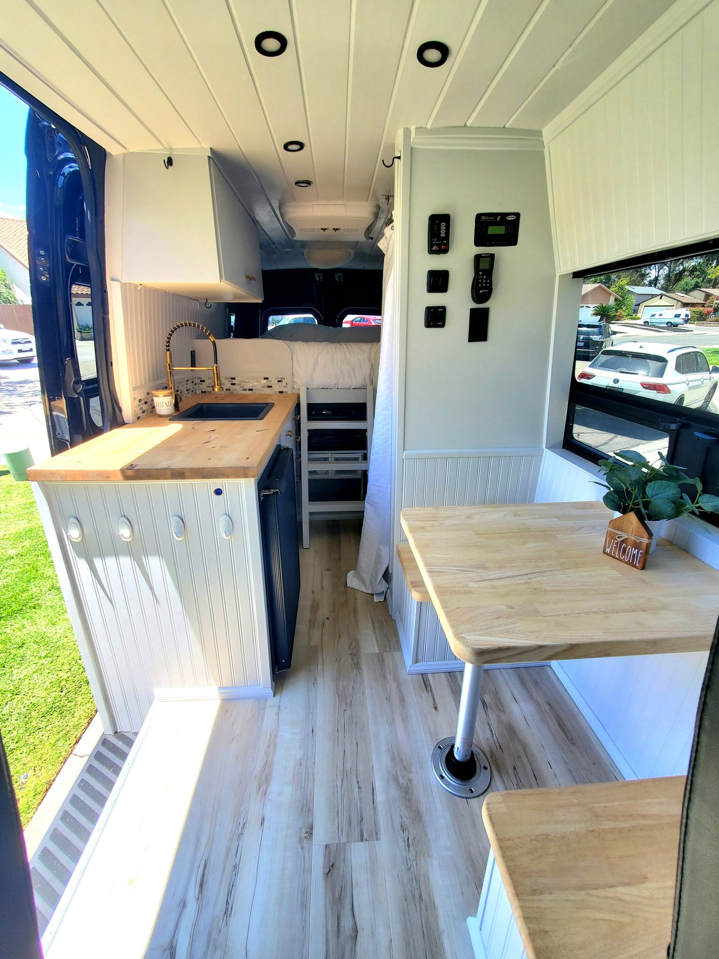 Cozy RV rental interior with modern kitchen, dinette, and sleeping area. Enjoy comfortable mobile living in this converted van.