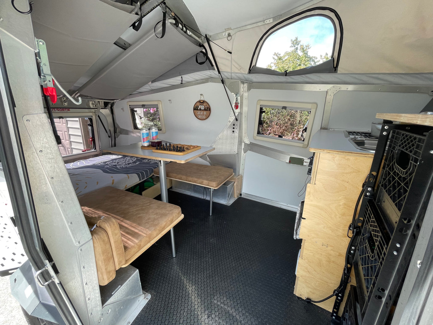 Compact RV rental interior featuring a cozy sleeping area, versatile dining space, and kitchenette. Ideal for travel adventures.