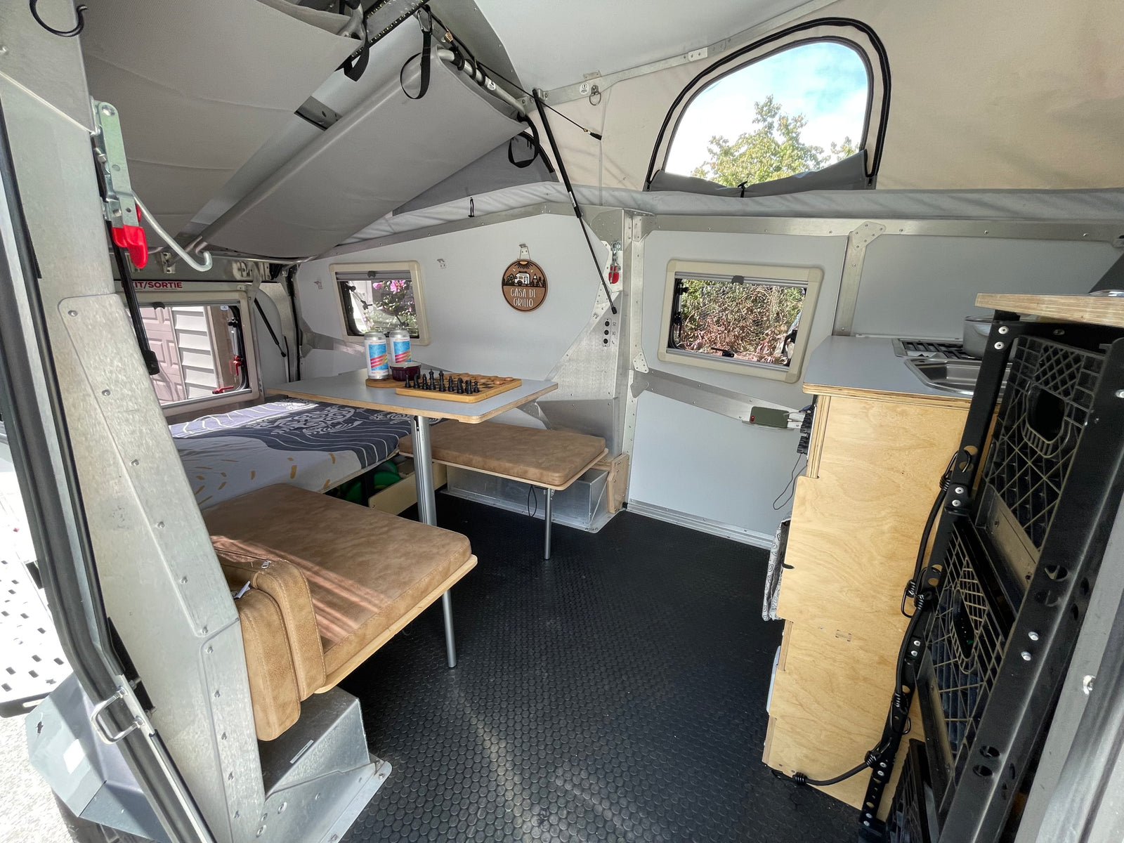 Compact RV rental interior featuring a cozy sleeping area, versatile dining space, and kitchenette. Ideal for travel adventures.