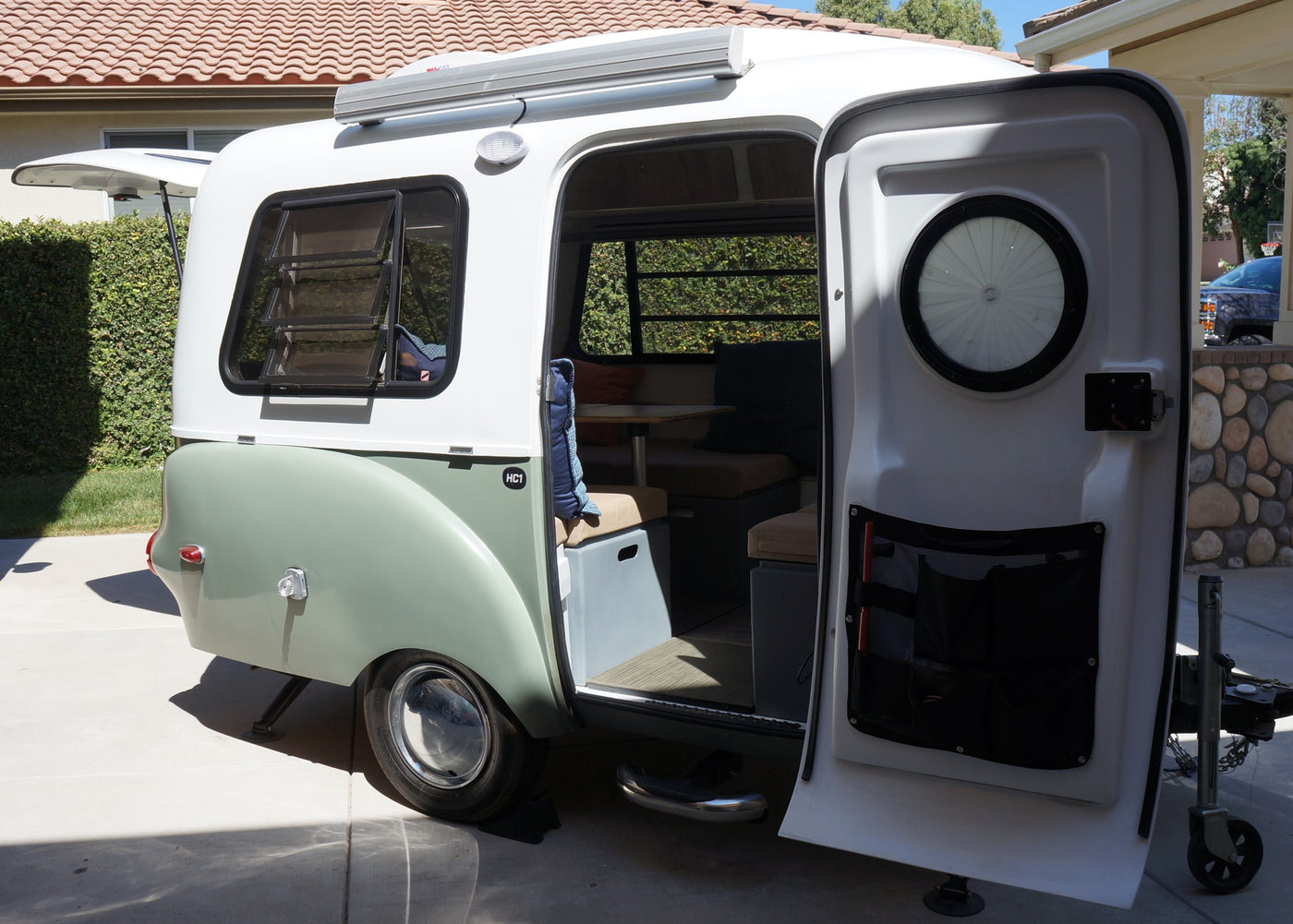 This compact, stylish camper trailer, perfect for RV rental, shows its open door and cozy interior for travel. — photo 9