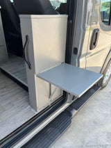 This RV rental van conversion features a convenient fold-out table at the open side door, ideal for camping and outdoor activities.