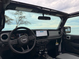 Jeep interior with dashboard, infotainment screen, and scenic ocean view. Great for an rv rental adventure!
