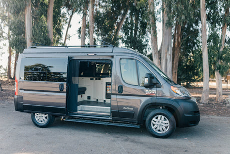 Grey Ram ProMaster camper van with open side door showing interior, ideal for your next rv rental adventure.