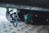 Close-up of an RV rental drain valve, essential for water tank maintenance on the underside of the vehicle.