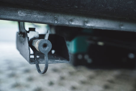 Close-up of an RV rental drain valve, essential for water tank maintenance on the underside of the vehicle.
