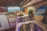Cozy RV rental interior with a fully equipped kitchenette and a breathtaking beach view. Perfect for your next adventure!