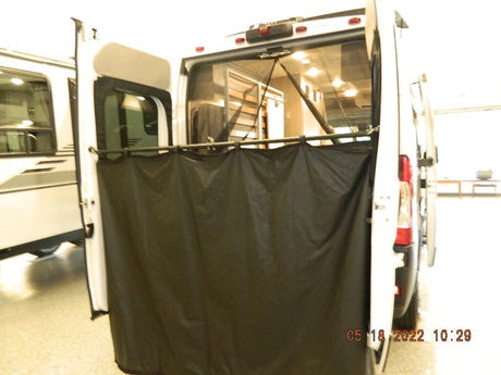 RV rental van showing its rear open doors with a deployed privacy curtain, creating an outdoor shower/changing area.