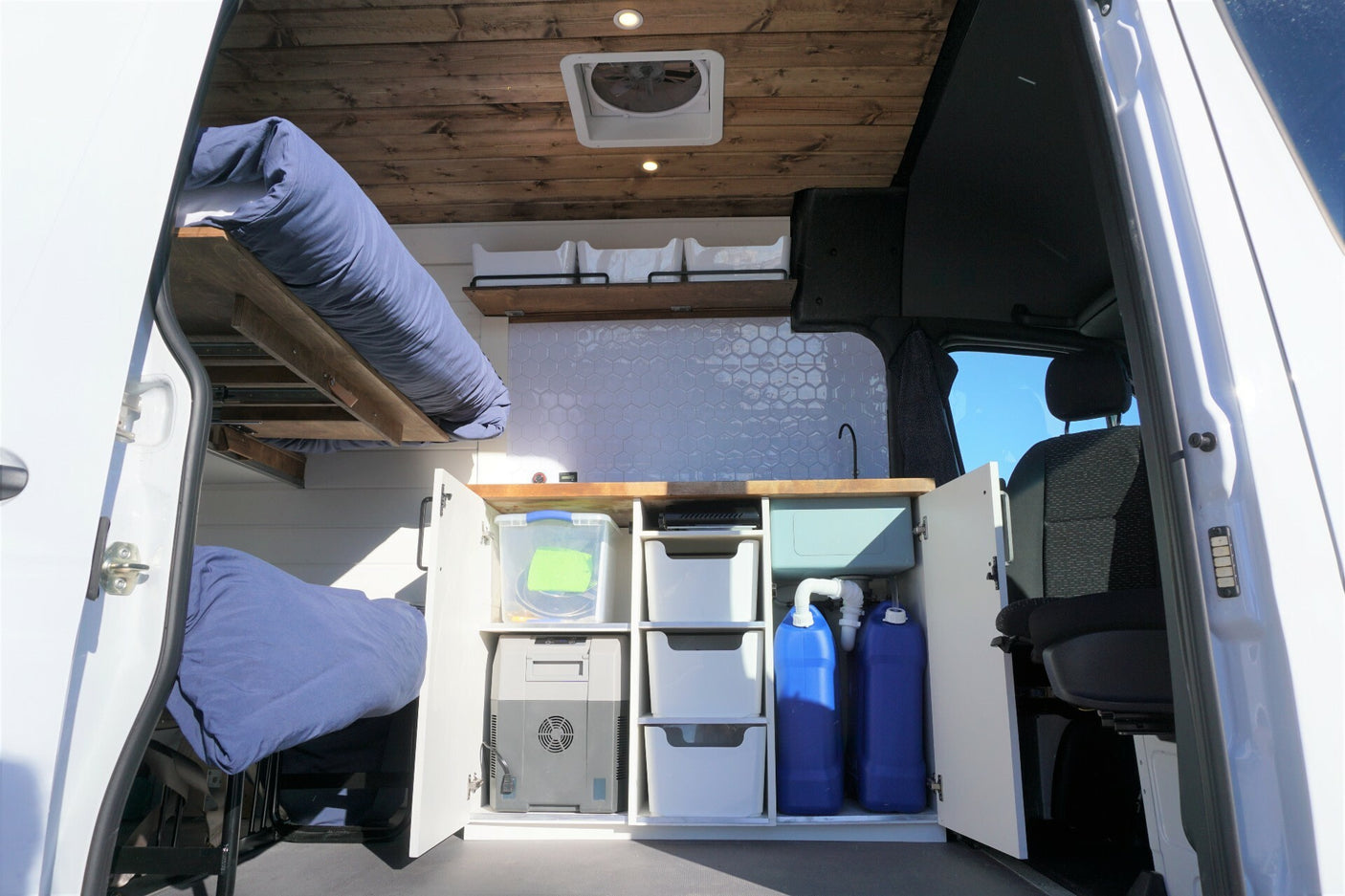 Discover the well-equipped interior of this rv rental, showcasing a functional kitchen, bunk beds, and clever storage solutions.