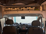 Inside this RV rental: front seats, dashboard, and practical overhead storage bins. Ready for your adventure.