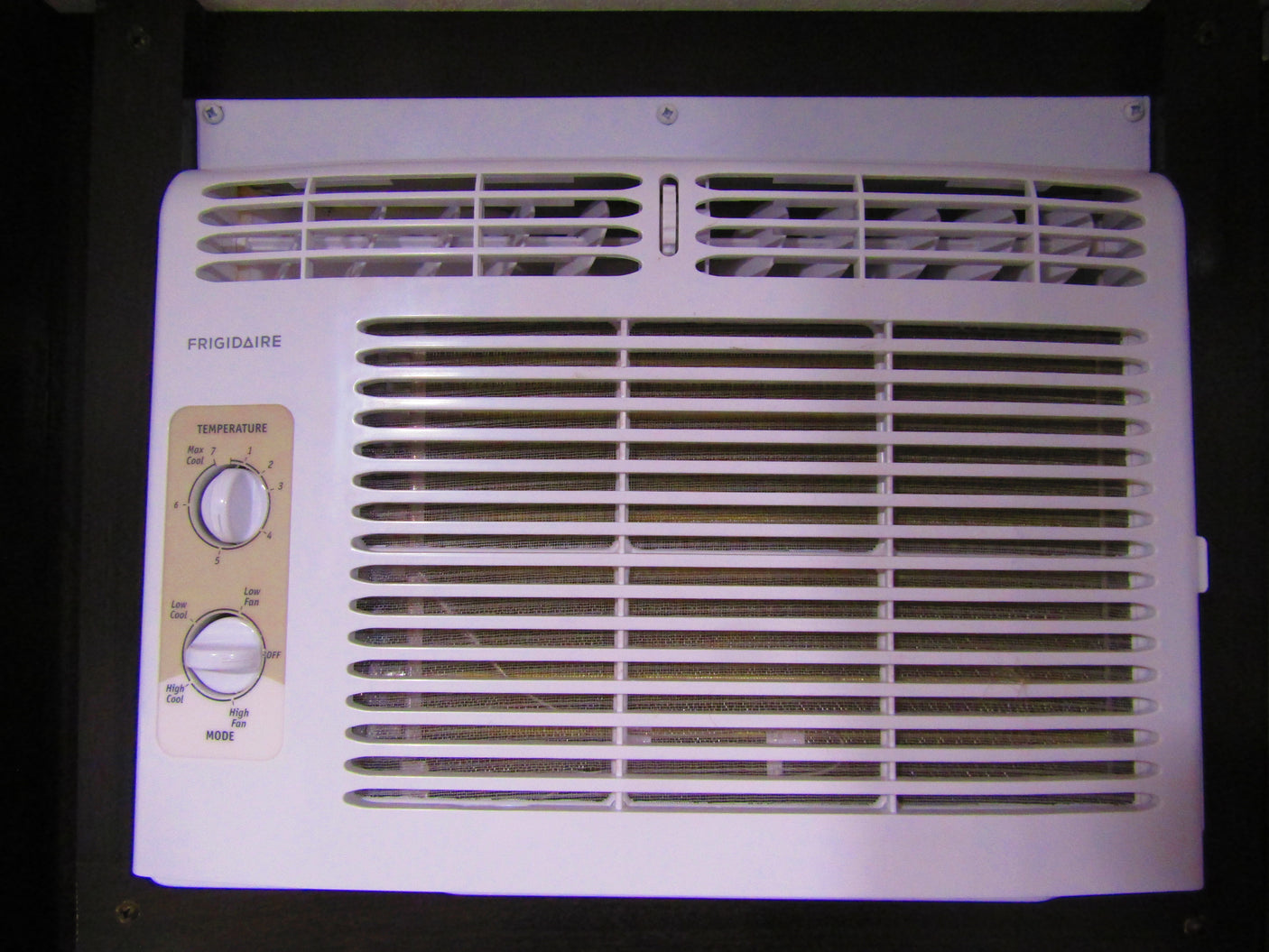 A white Frigidaire air conditioner unit, often found in an RV rental, showing its temperature and mode control dials.