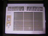 A white Frigidaire air conditioner unit, often found in an RV rental, showing its temperature and mode control dials.