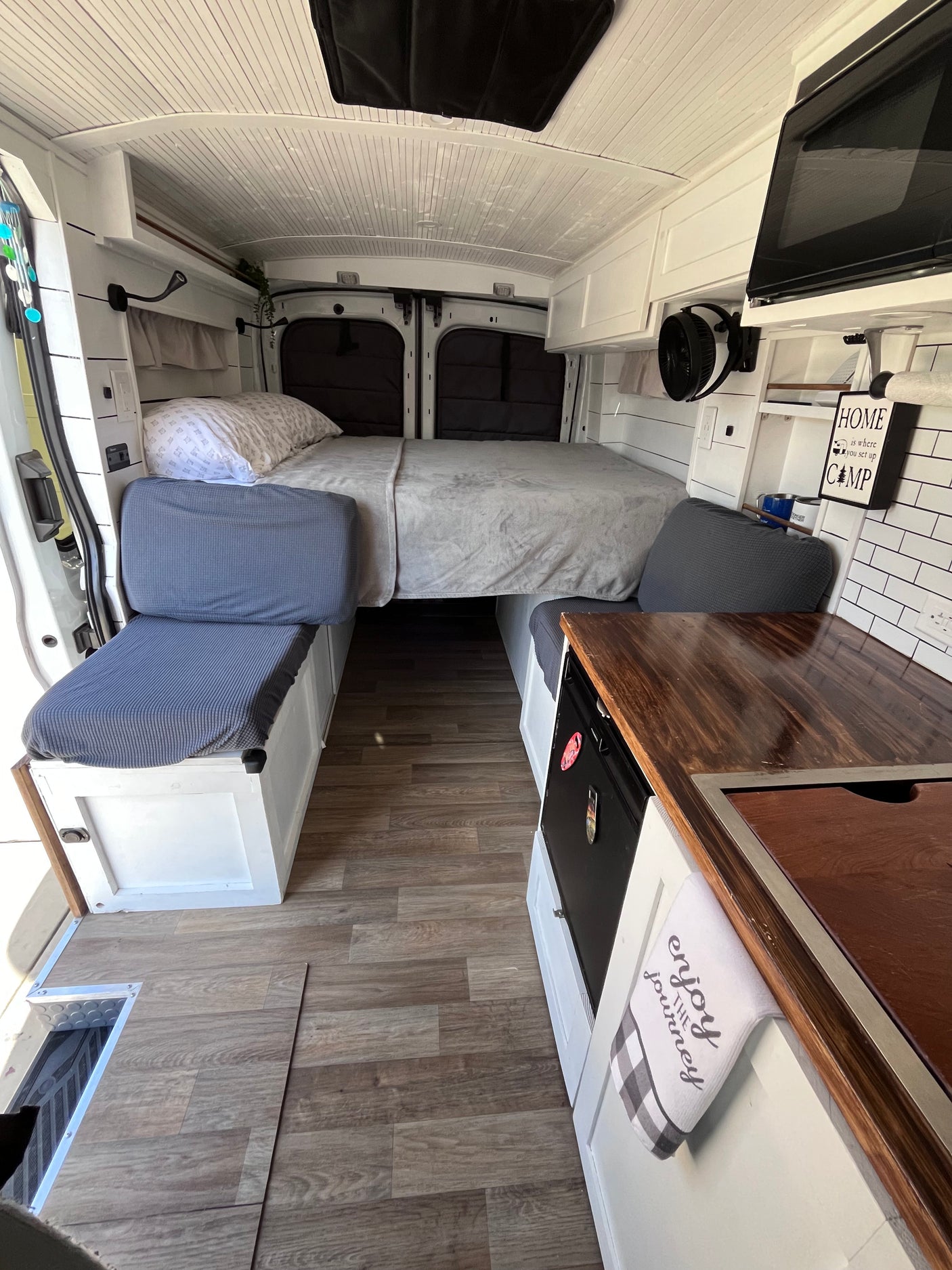 Inside a clean RV rental: compact camper van interior with bed, kitchen, and seating area, ideal for travel.
