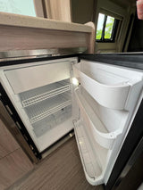 Clean, open refrigerator and freezer in an RV rental. Ready for your adventure's food and drinks.