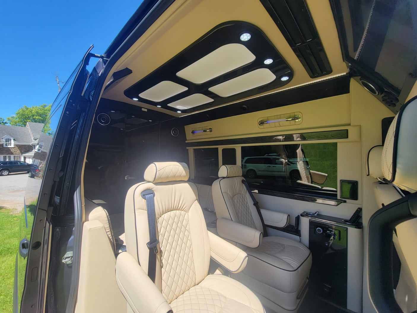 Luxurious RV rental interior with plush cream leather captain seats, ambient LED lighting, and entertainment console. Ideal for travel.