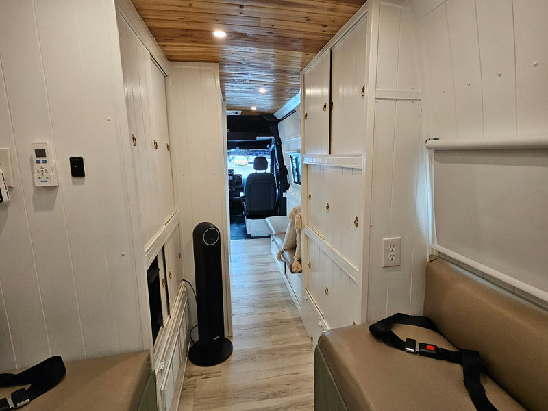  and a toilet with bidet and toilet paper holder on the right.|A compact RV rental bedroom with a bed featuring a green and white patterned quilt — photo 8
