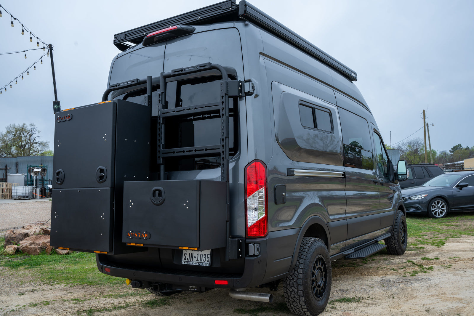 Grey custom camper van, ideal for rv rental, features unique rear storage boxes & an adventure-ready build.