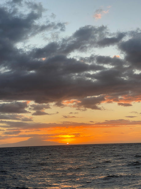 Golden sunset over calm ocean waves & clouds. A perfect end to an RV rental day.