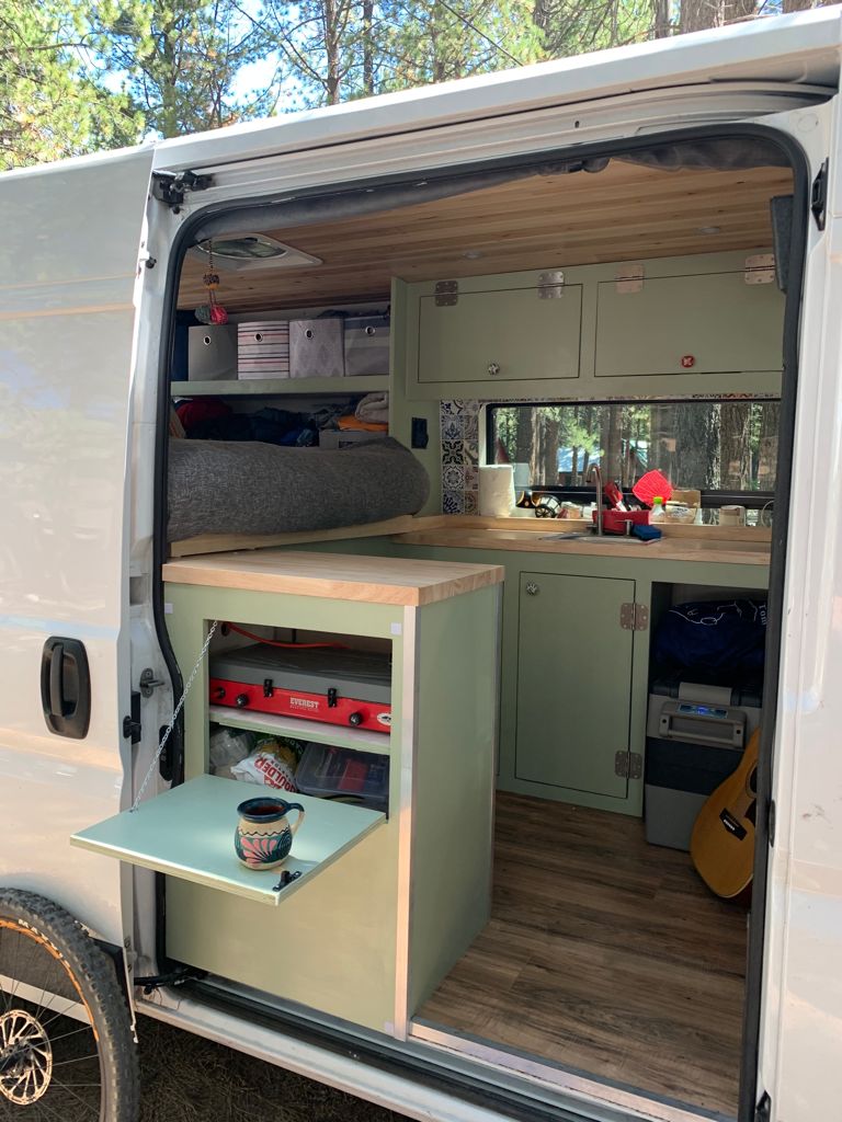 Discover this custom camper van conversion for your rv rental! Features a compact kitchen, bed, and smart storage solutions. — photo 4