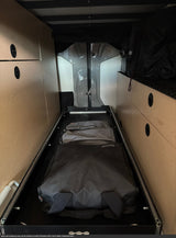 Maximizing space in this **rv rental**: pull-out cargo tray with travel bags, nestled in custom wooden cabinetry.
