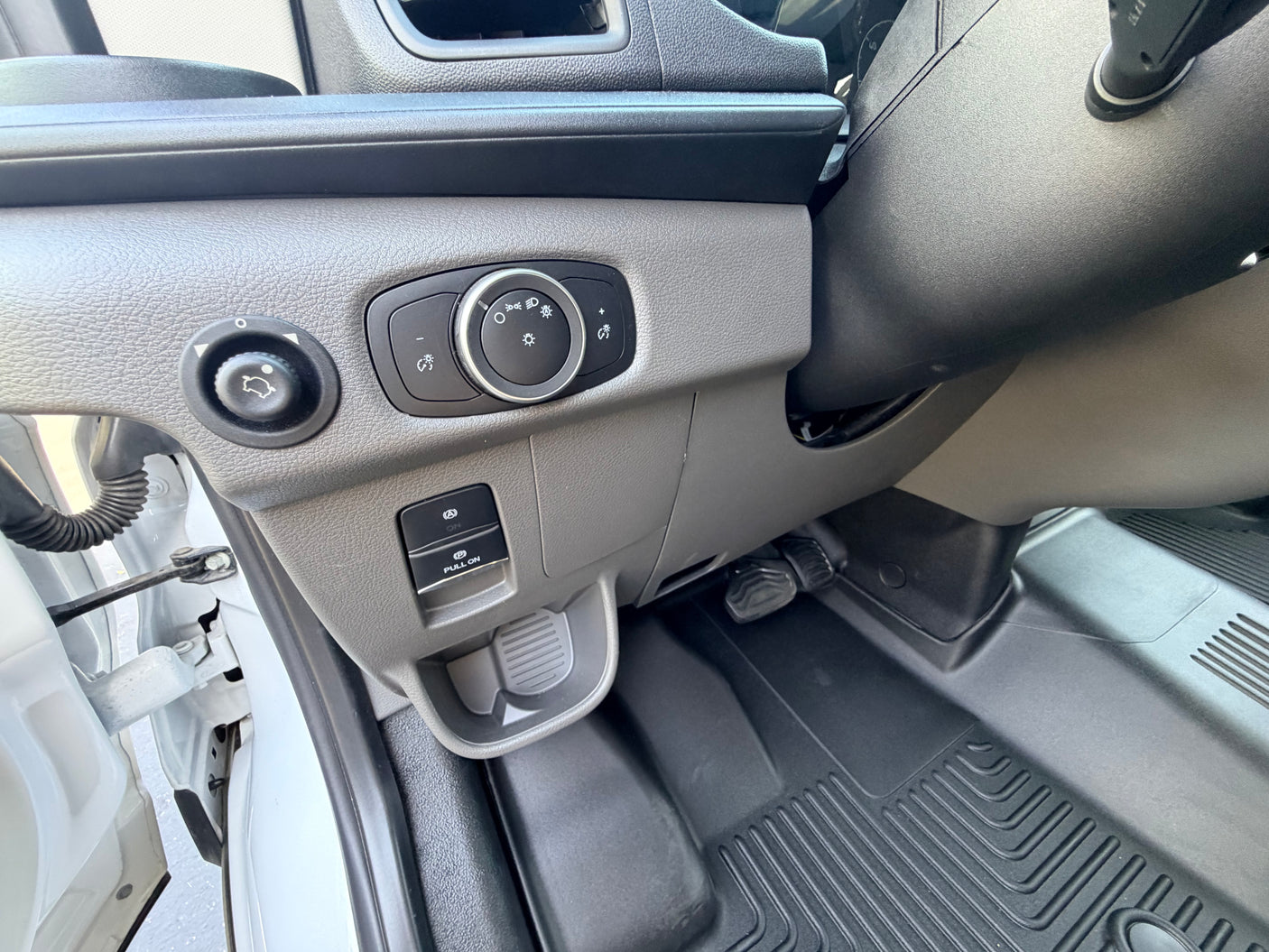 RV rental: Driver's area with light/mirror controls, electronic parking brake, and durable floor mat for convenience.