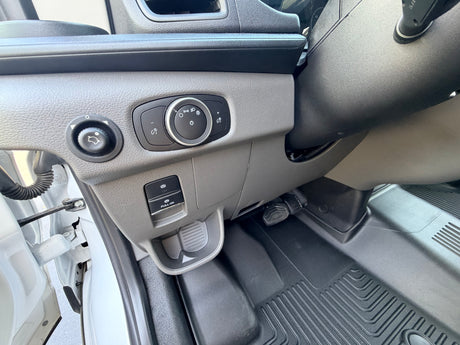 RV rental: Driver's area with light/mirror controls, electronic parking brake, and durable floor mat for convenience.