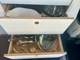Compact rv rental kitchen with organized drawers. Cookware, pots, pans, colander & measuring cup neatly stored.