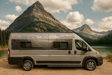 Gray ROAM rv rental camper van by a serene mountain lake, surrounded by majestic peaks and evergreen trees.