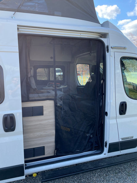 An RV rental camper van's open side door, showcasing its interior layout, pop-top roof, and functional screen.