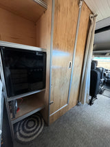 Inside a spacious RV rental: custom wood cabinets, integrated fridge, and front cabin view for your road trip adventure.
