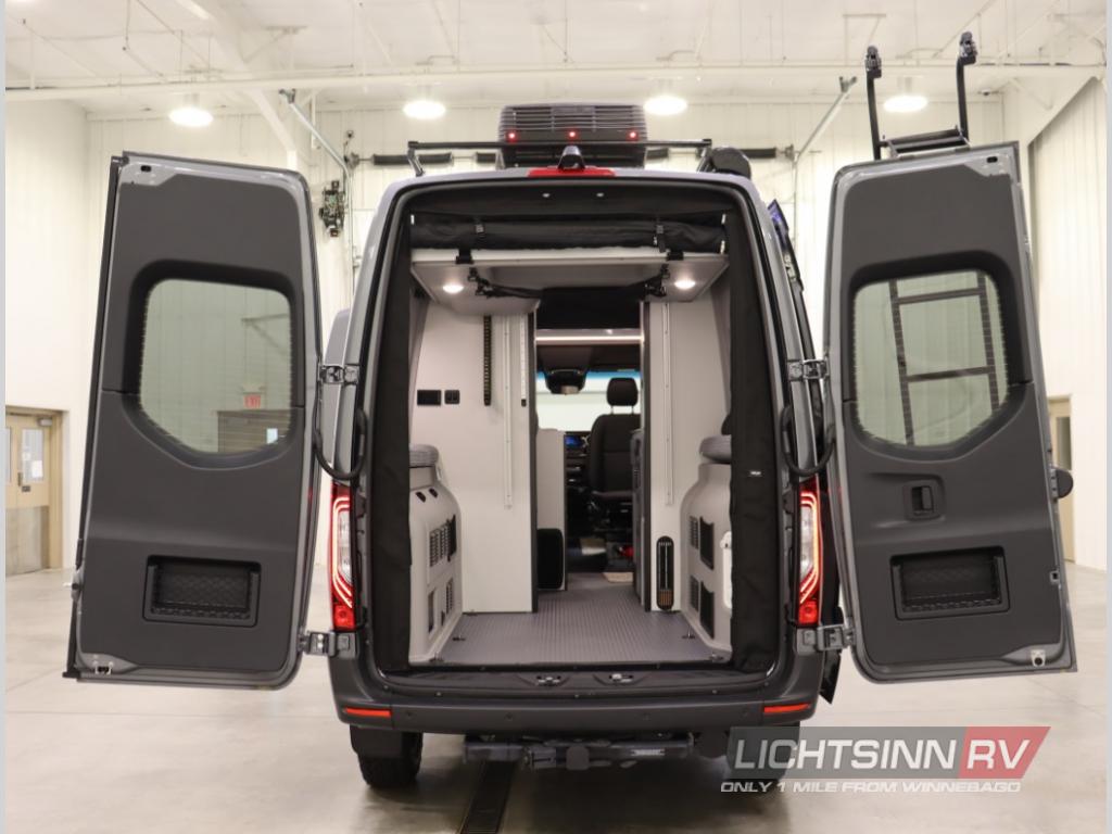 RV rental: Rear view of a gray camper van with wide open doors, showcasing its spacious, adventure-ready interior.