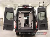 RV rental: Rear view of a gray camper van with wide open doors, showcasing its spacious, adventure-ready interior.