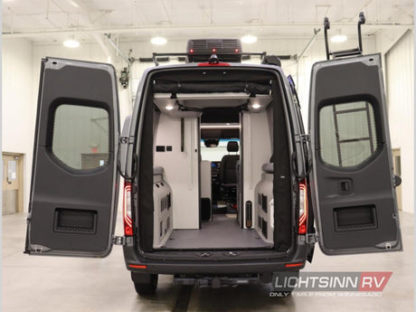 RV rental: Rear view of a gray camper van with wide open doors, showcasing its spacious, adventure-ready interior.