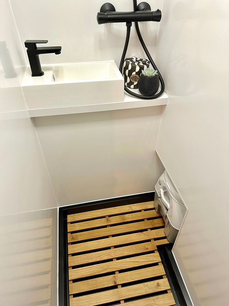 Modern RV rental wet bath, featuring a sleek black sink, shower, and discrete portable toilet on a wooden slatted floor. — photo 15