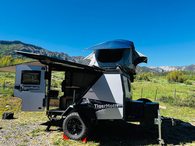 Enjoy a TigerMoth overland trailer RV rental, featuring a rooftop tent, set up for camping in a scenic mountain landscape. — photo 4