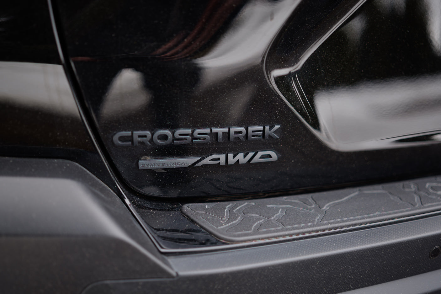 Black Subaru Crosstrek's rear. Features 'CROSSTREK SYMMETRICAL AWD' emblems. Perfect for trips, even complementing an rv rental.