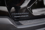 Black Subaru Crosstrek's rear. Features 'CROSSTREK SYMMETRICAL AWD' emblems. Perfect for trips, even complementing an rv rental.